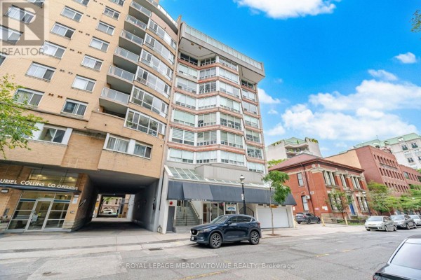 View of the apartment building entrance and surrounding streetscape with parked cars. - 610 - 82 Lombard Street, Toronto