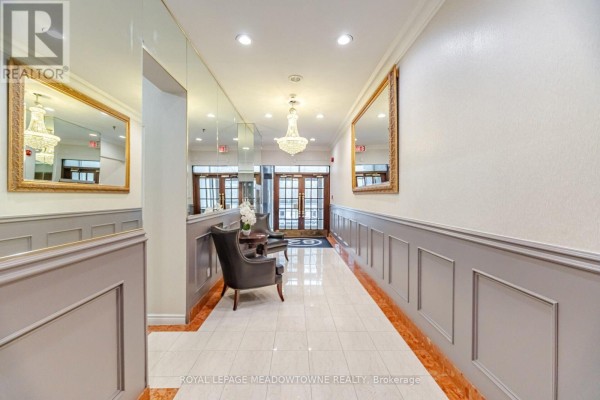 Hallway with marble floors, grey wainscoting, mirrors, and a crystal chandelier. - 610 - 82 Lombard Street, Toronto