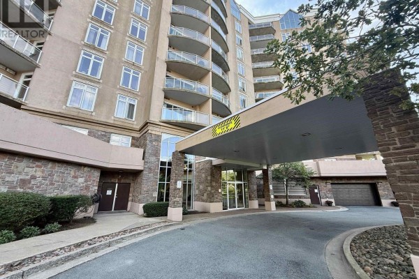 Covered entrance to The Roxbury condo building with stone accents and glass doors. - 610 202 Walter Havill Drive, Halifax
