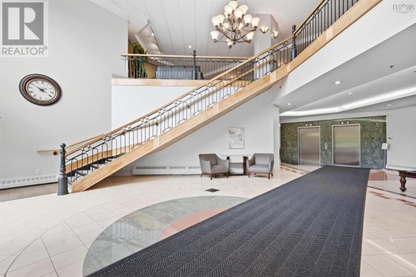 Lobby of The Roxbury condo building with a grand staircase, elevators, and seating area. - 610 202 Walter Havill Drive, Halifax