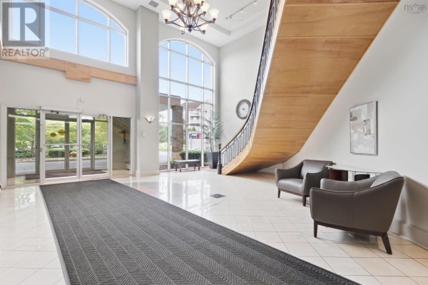 Spacious lobby with large windows, grand staircase, seating area, and tile flooring. - 610 202 Walter Havill Drive, Halifax