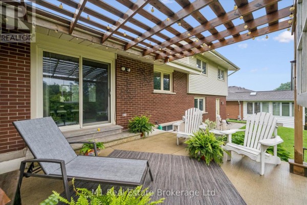 Pergola-covered patio with chaise lounge, Adirondack chairs, and string lights - 610 St David Street S Centre Wellington