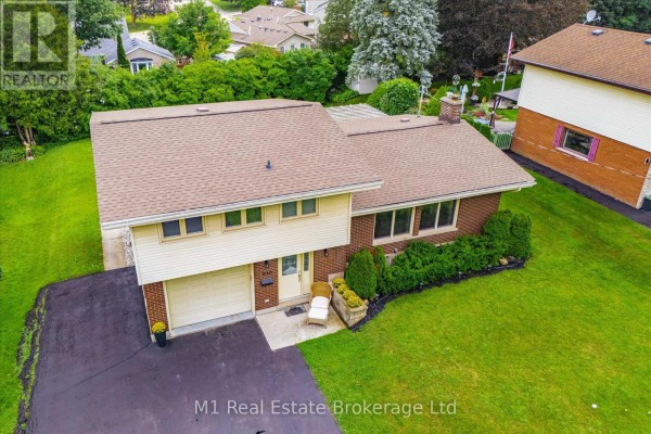House with attached garage, brick and siding exterior, and green lawn - 610 St David Street S Centre Wellington