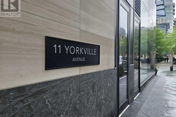 Close-up of a black plaque reading "11 YORKVILLE AVENUE" on a stone wall. - 6105 - 11 Yorkville Avenue, Toronto