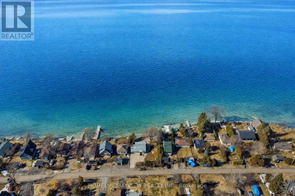 Aerial view of cottages along the shoreline with clear, shallow water. - 6108 Curtis Pt Road, Alderville First Nation