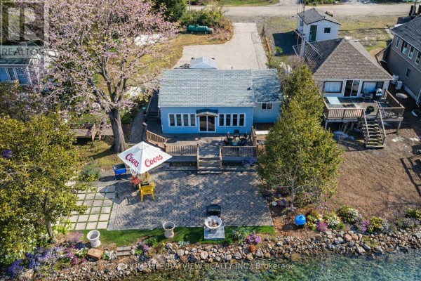 Aerial view of waterfront bungalow with deck, patio, and lake. - 6108 Curtis Pt Road, Alderville First Nation