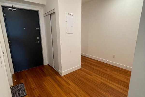 Entryway with hardwood flooring, closet, and modern door. - 611 - 1 Wellington Street, Brantford