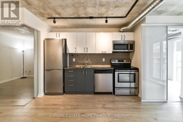 Close-up of the kitchen area with stainless steel appliances and grey and white cabinetry. - 611 - 170 Sudbury Street, Toronto