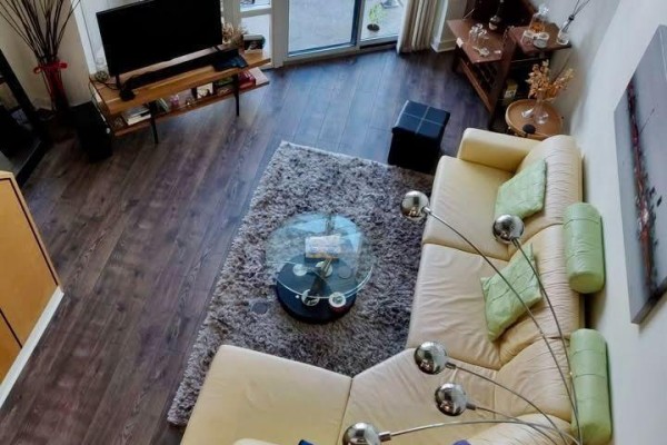 Overhead view of a living room with a sectional sofa, coffee table, and television. - 611 - 255 Richmond Street E, Toronto