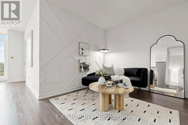 Living area with textured wall, black sofa, wooden coffee table, and mirrored accent. - 611 - 31 Tippett Road, Toronto