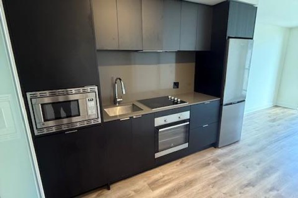 Close-up of the kitchen counter with microwave, sink, stove, and oven. - 611 - 86 Dundas Street E, Mississauga
