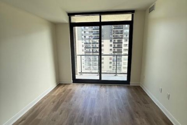 Living room with a large sliding glass door leading to a balcony with city views. - 611 - 86 Dundas Street E, Mississauga