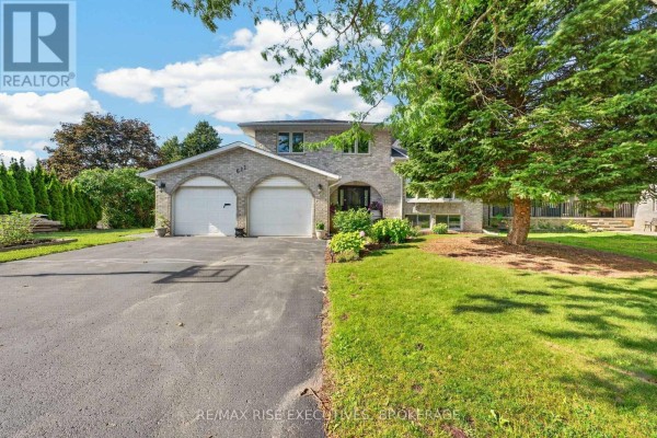 Front exterior view of a brick house with a double garage and a manicured lawn. - 611 Rivermeade Avenue, Kingston