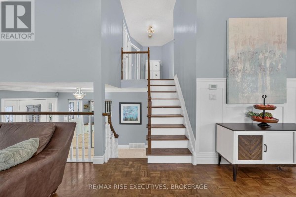 Hallway with parquet flooring, staircase, abstract art and console table - 611 Rivermeade Avenue Kingston