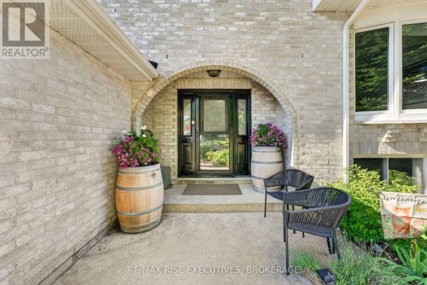 Front entrance with an arched brick detail, double doors, and two wine barrel planters. - 611 Rivermeade Avenue, Kingston