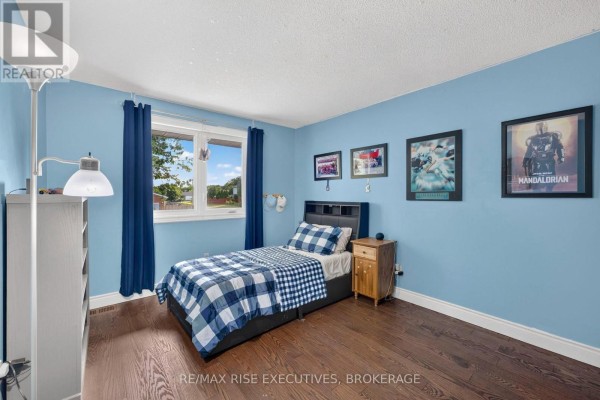 Bedroom with blue checkered bedding, wood floors, and posters - 611 Rivermeade Avenue Kingston