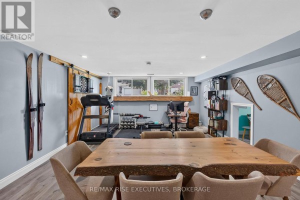 Live-edge dining table, treadmill, weights, punching bag, and office desk in finished basement - 611 Rivermeade Avenue Kingston
