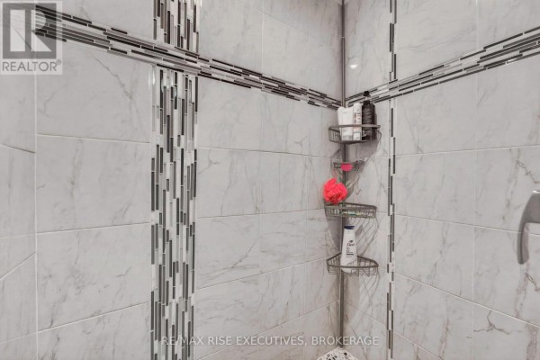 Marble-look shower tiles with accent strip and caddy - 611 Rivermeade Avenue Kingston