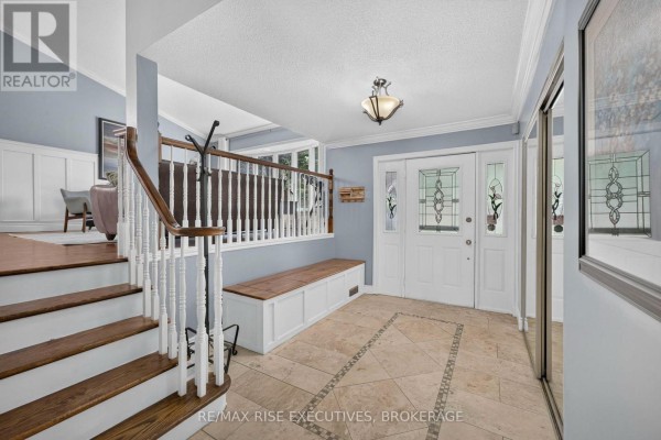 Interior foyer with beige tile flooring, white trim, a wooden bench, and double entry doors. - 611 Rivermeade Avenue, Kingston