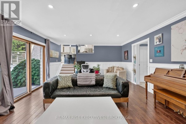 Living room with leather sofa, piano, and sliding glass doors - 611 Rivermeade Avenue Kingston