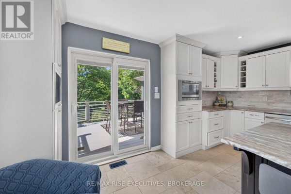 White cabinets, granite countertops, and deck access in kitchen - 611 Rivermeade Avenue Kingston