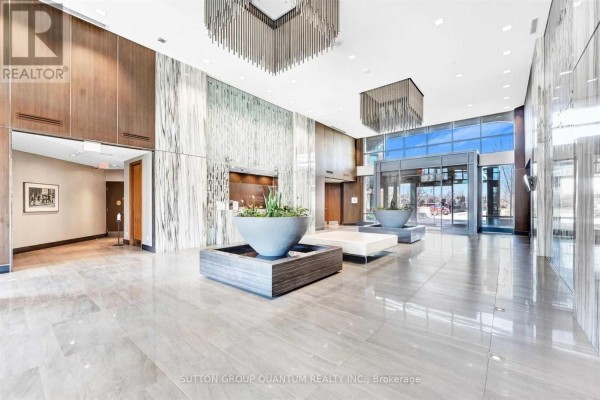 Spacious building lobby with marble floors, wood paneling, and large planters. - 612 - 205 Sherway Gardens Road, Toronto