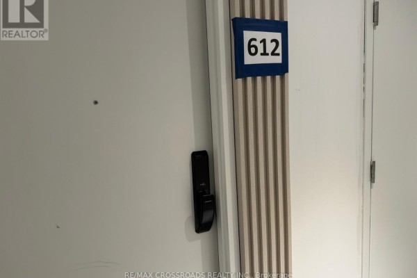 Apartment door 612 with a black handle and a vertical ribbed panel. - 612 - 28 Ann Street, Mississauga