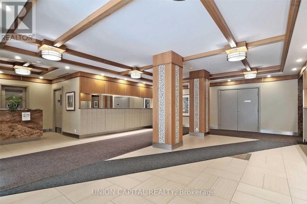 Building lobby with wood-paneled walls, decorative columns, and tile floor. - 612 - 32 Clegg Road, Markham