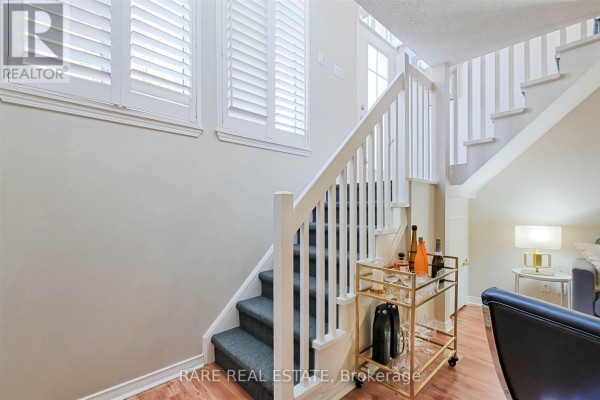 Interior staircase with white railings, grey carpet, and a bar cart. - 612 - 38 Western Battery Road, Toronto