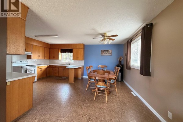 Kitchen and dining area with wood cabinets, beige flooring, and a ceiling fan. - 612 2nd Street W, Meadow Lake