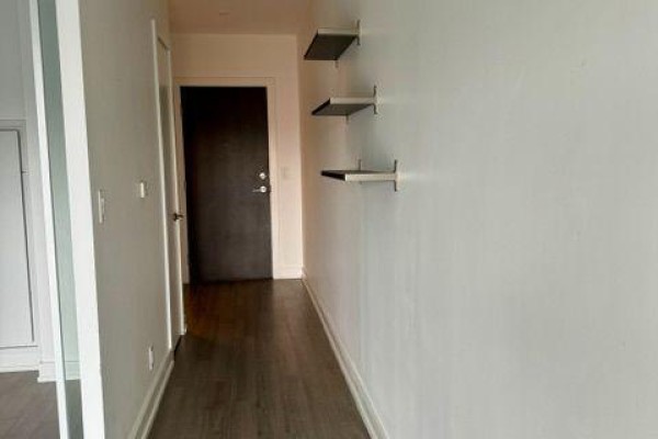 Bedroom with a queen-sized bed, large mirrored closet, and sliding door closet. - 613 - 6 Parkwood Avenue, Toronto