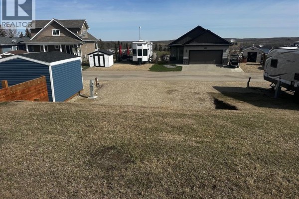 View of a rural street with houses, RVs, sheds, and gravel lots. - 6134, 25054 South Pine Lake Road, Rural Red Deer County