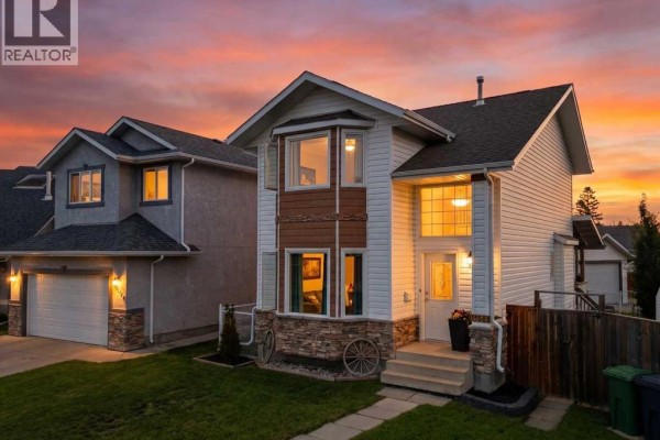 Bedroom with a queen bed, large wood closet doors, and a television on the wall. - 6134 52 Street Close, Ponoka
