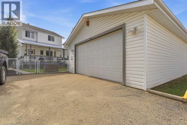 Entryway with a glass-paned door, a shoe rack, and large wood closet doors. - 6134 52 Street Close, Ponoka