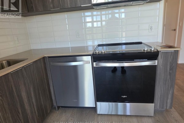 Kitchen area with stainless steel dishwasher, black stove, grey wood cabinets, and light countertop. - 614 - 740 Whitlock Avenue, Milton