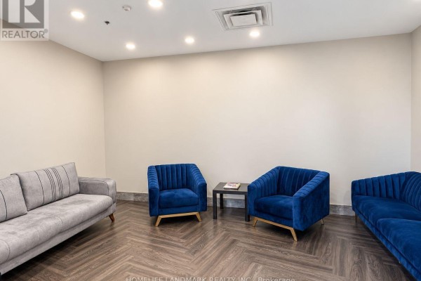 A small lounge area with a grey sofa and two blue velvet armchairs. - 614 - 7711 Green Vista Gate, Niagara Falls
