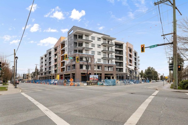 Exterior view of a multi-story apartment building under construction with traffic lights. - 614 20769 Fraser Highway, Langley