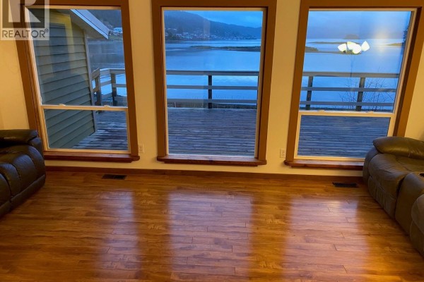 Living room with hardwood floors and leather seating, large windows - 614 5th Avenue, Daajing Giids City