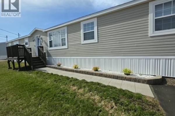 View down the stone walkway and side of the mobile home toward the street. - 614 Champlain, Shediac
