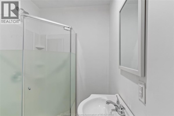 Laundry room with front-loading washer and dryer, and cabinetry - 614 Elliott Street East, Windsor