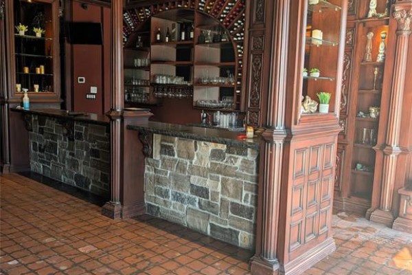 Close-up of two dark wood bars with stone tile bases and granite countertops. - 614 Erie Street East, Windsor