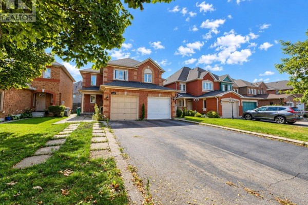 Street view of a brick house with a paved driveway and manicured lawn. - 6143 Snowy Owl Crescent, Mississauga