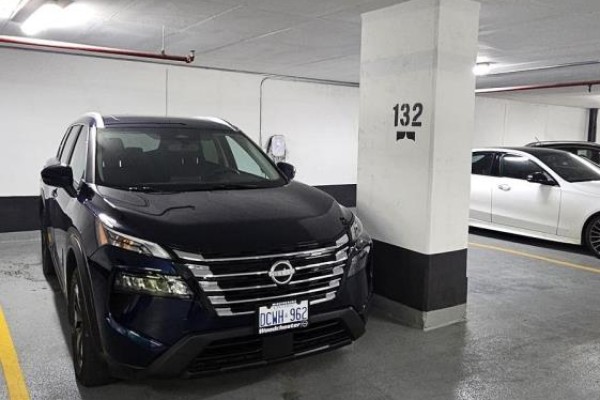 Dark blue Nissan SUV parked in an underground garage next to a concrete pillar. - 615 - 28 Ann Street, Mississauga