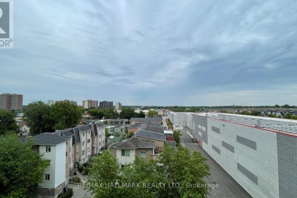 Living area with grey sofa, coffee table, and large window with city view. - 615 - 8 Trent Avenue, Toronto