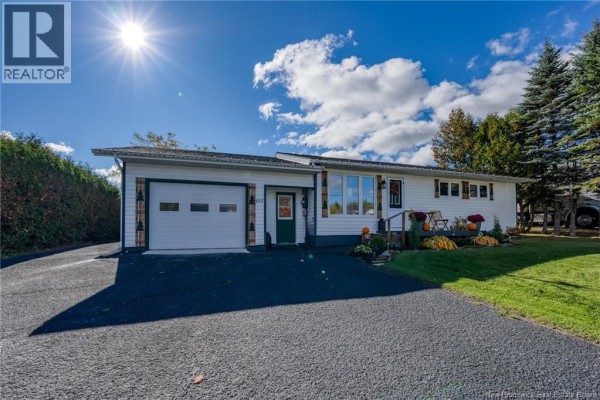 Driveway and garage entrance of a white bungalow exterior. - 615 5th Avenue, Grand Sault/grand Falls