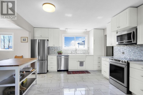Modern kitchen with white cabinets, stainless steel appliances, and island - 6151 Malakoff Road Ottawa