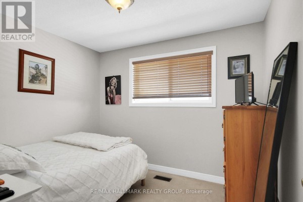 Bedroom with bed, dresser, TV, mirror, and window blinds - 6151 Malakoff Road Ottawa