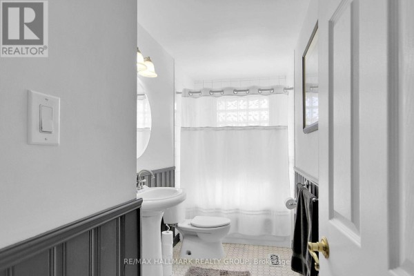 Bathroom with pedestal sink, toilet, and shower curtain - 6151 Malakoff Road Ottawa