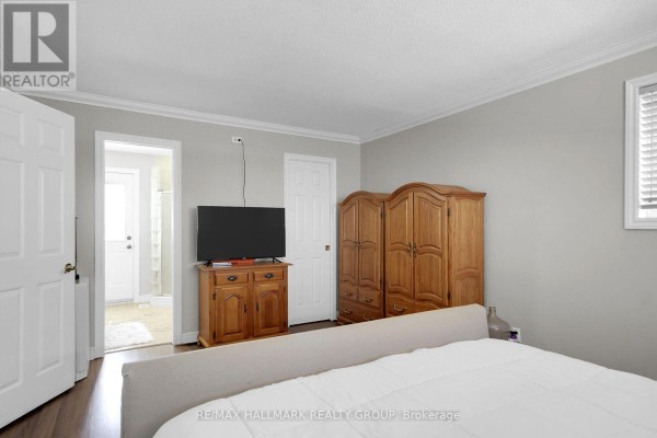 Bedroom with wood armoire, TV stand, and bed - 6151 Malakoff Road Ottawa