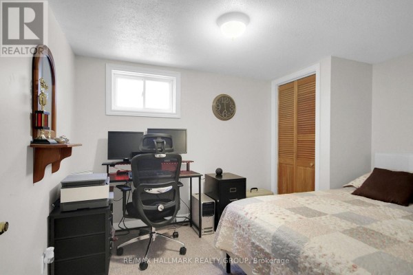 Bedroom with dual monitors, office chair, printer, louvered closet doors, and bed - 6151 Malakoff Road Ottawa